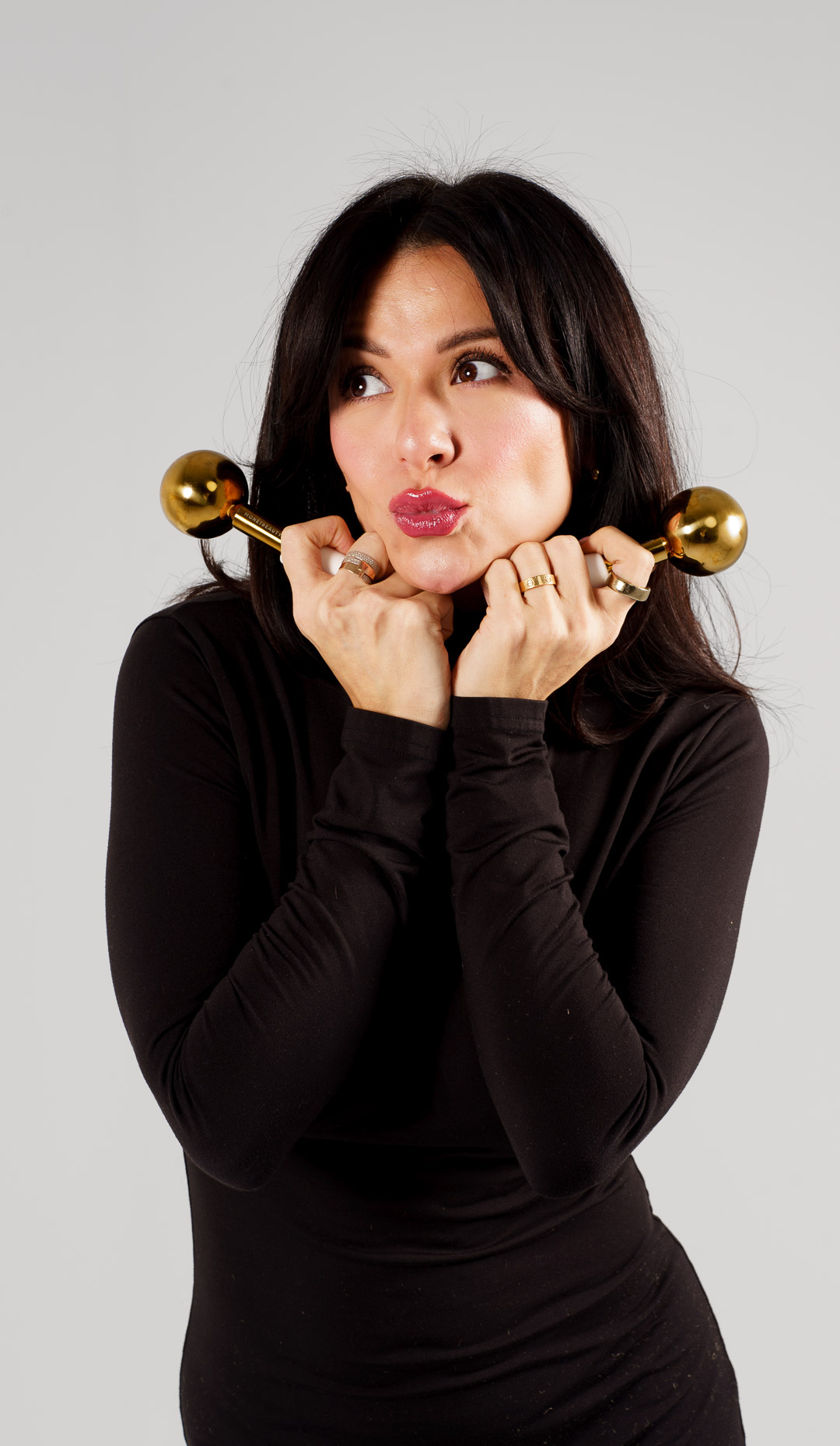 Esthetician holding gold facial massage tools used during a customized facial in Huntingdon Valley PA
