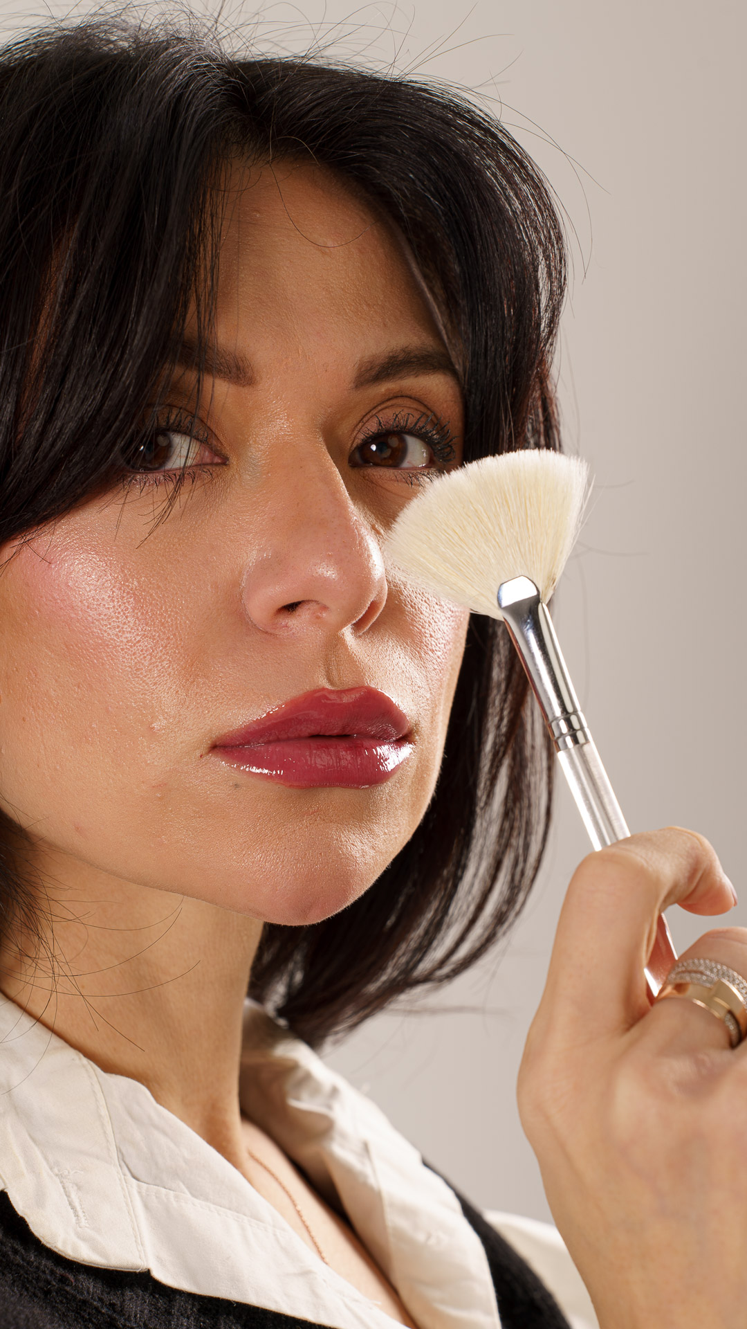 Close-up of glowing, refreshed skin as an esthetician holds a fan brush used for peel application at SkinArt Aesthetics in Huntingdon Valley, PA